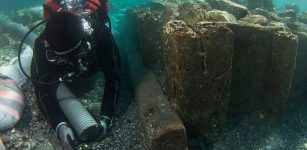 Archaeologist documenting wooden caisson (V. Tsiairis).