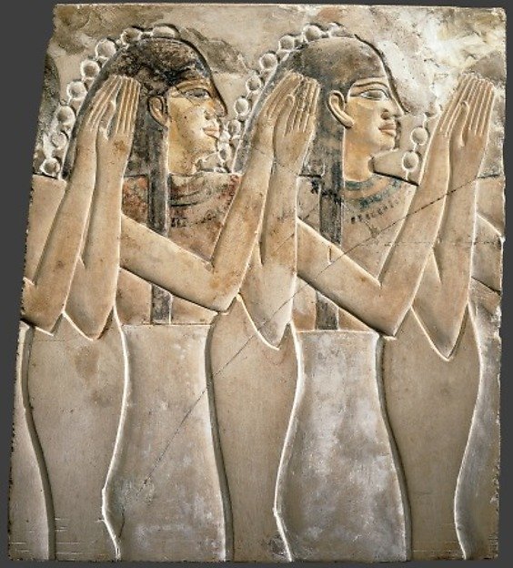 Ancient relief of clapping Egyptian women.