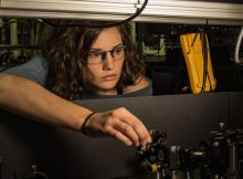 NIST physicist Katie McCormick adjusts a mirror to steer a laser beam used to cool a trapped beryllium ion (electrically charged atom). McCormick and colleagues got the ion to display record-setting levels of quantum motion, an advance that can improve quantum measurements and quantum computing. Credit: Burrus/NIST