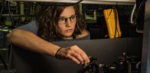 NIST physicist Katie McCormick adjusts a mirror to steer a laser beam used to cool a trapped beryllium ion (electrically charged atom). McCormick and colleagues got the ion to display record-setting levels of quantum motion, an advance that can improve quantum measurements and quantum computing. Credit: Burrus/NIST