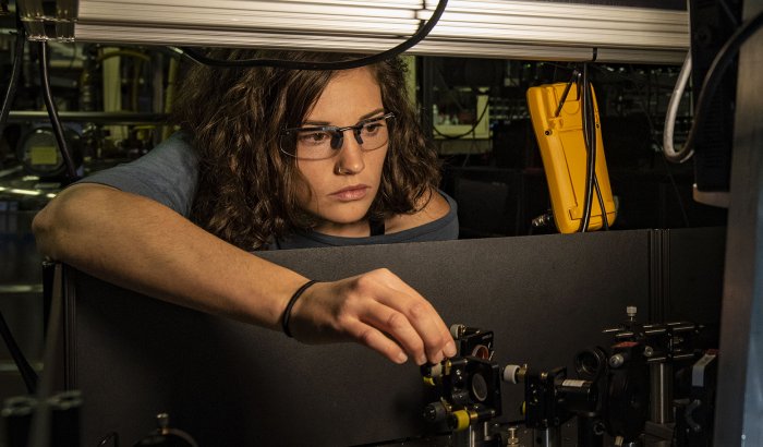 NIST physicist Katie McCormick adjusts a mirror to steer a laser beam used to cool a trapped beryllium ion (electrically charged atom). McCormick and colleagues got the ion to display record-setting levels of quantum motion, an advance that can improve quantum measurements and quantum computing. Credit: Burrus/NIST