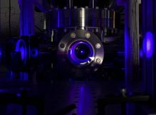 One of the first steps in creating the optical atomic clocks used in this study is to cool strontium atoms to near absolute zero in a vacuum chamber, which makes them appear as a glowing blue ball floating in the chamber. Credit: Shimon Kolkowitz