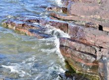 Ironstones deposited on the seafloor nearly two billion years ago now occur as rocky outcrops along the lakeshore of Tu Nedhé (Northwest Territories, Canada). Credit: Devon Cole / Des roches ferrugineuses qui se sont déposées sur le plancher océanique il y a près de deux milliards d’années prennent maintenant la forme d’un affleurement rocheux sur les rives du lac Tu Nedhé (Territoires du Nord-Ouest, Canada). Photo : Devon Cole