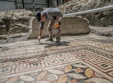 A worker cleans the mosaic on the floor of a recently discovered Roman villa in the Defne district of Hatay, southern Turkey, July 4, 2022. (AA Photo)