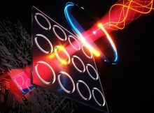 Illustration shows terahertz illumination (yellow curves at top right) entering the new camera system, where it stimulates quantum dots inside nanoscale holes (shown as illuminated rings) to emit visible light, which is then detected using a CMOS-based chip (bottom left) like those in digital cameras. Credits:Courtesy of the researchers